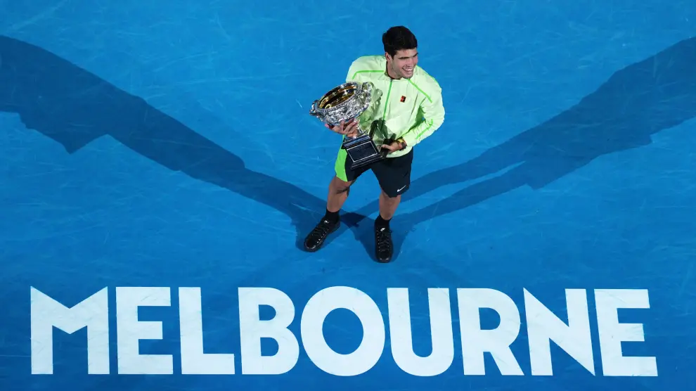 Carlos Alcaraz realizando un calentamiento relajado y sonriente, ejemplo de la gestión mental de Carlos Alcaraz para controlar la presión en el tenis.